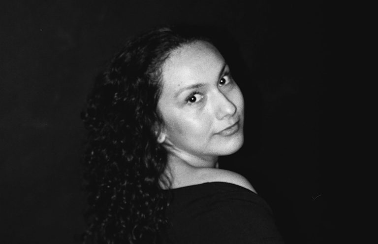 A woman looks back at the camera and smiles.