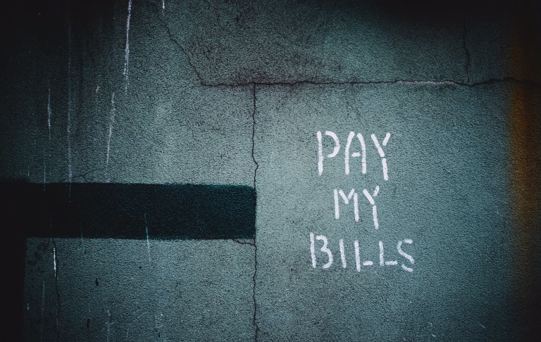 A picture of wall with the words "Pay My Bills" written on it to signify utility bill assistance